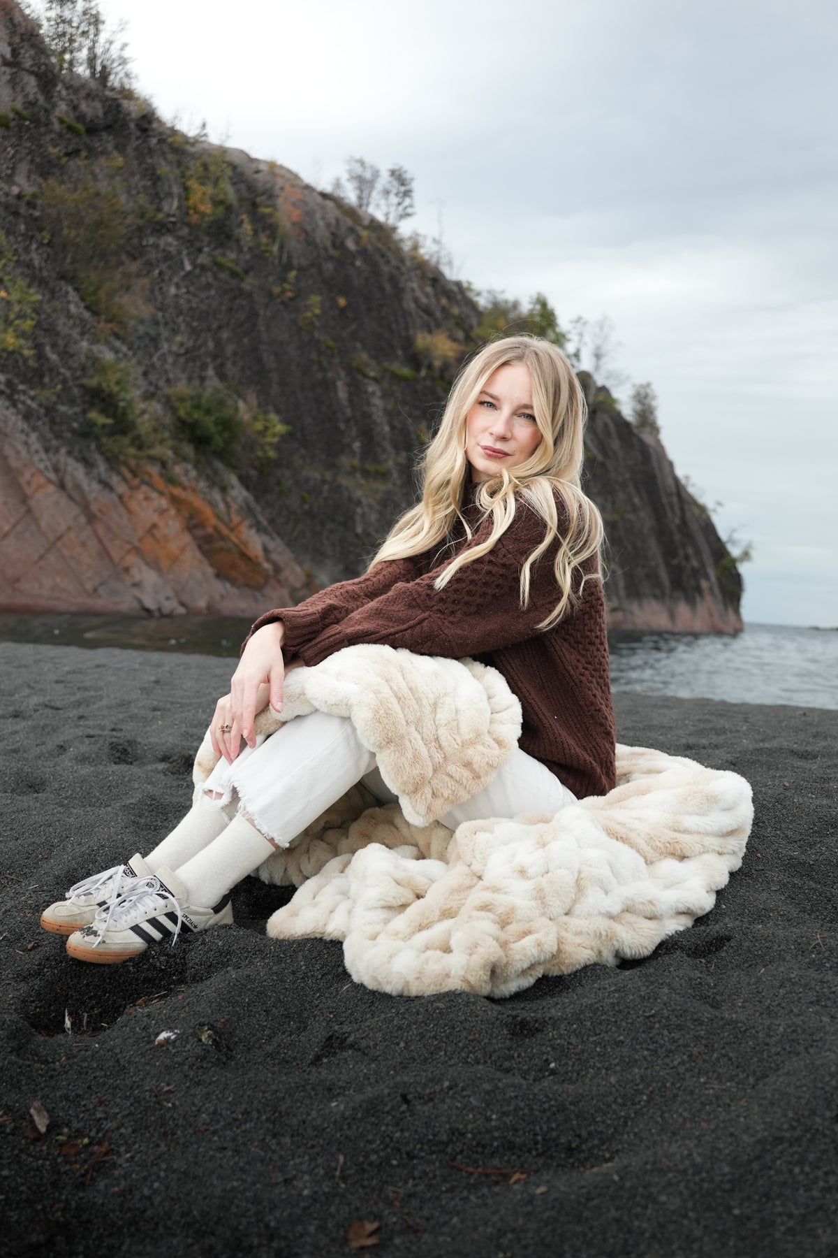 Cream faux fur blanket with chunky marbled texture, folded on the ground